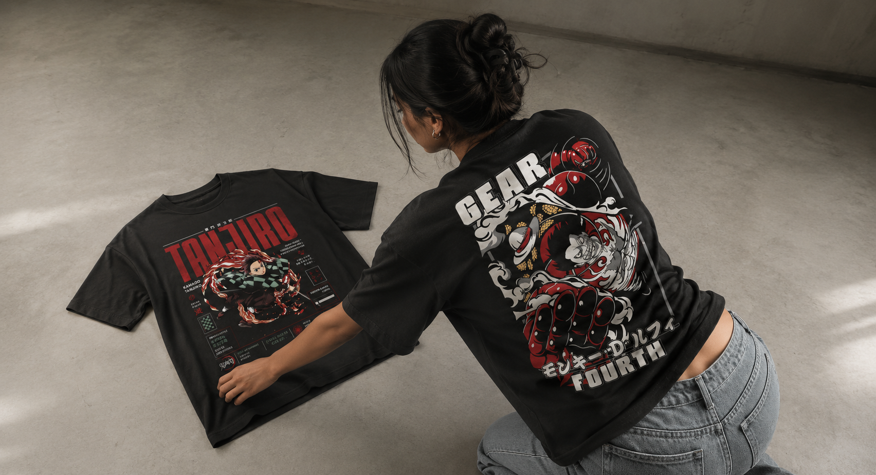 Person wearing a black t-shirt with graphic designs and text, standing on a concrete floor.
