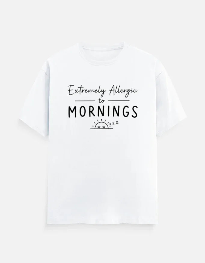 White graphic tee with 'Extremely Allergic to Mornings' text and sleepy sun design, bold streetwear style