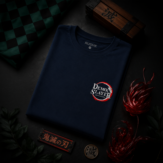 Navy blue t-shirt with 'Demon Slayer' logo on a dark surface with decorative elements.