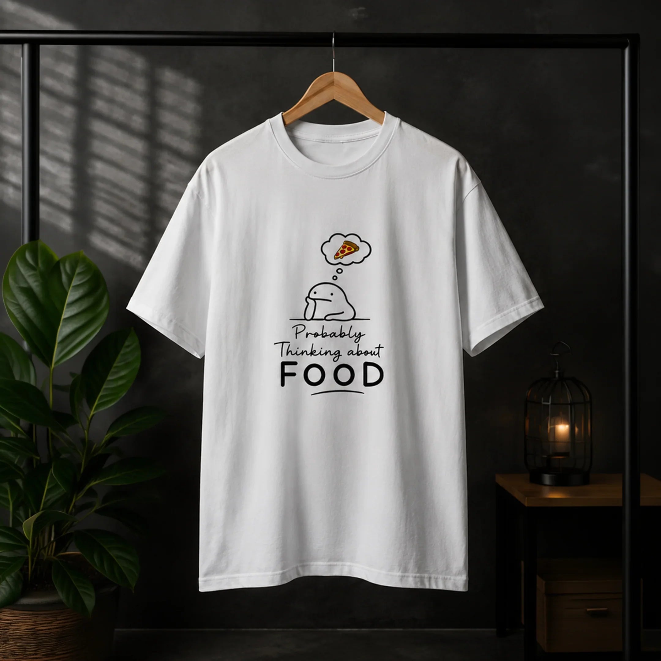White graphic tee with cute character thinking about pizza, bold 'Probably Thinking about FOOD' text, streetwear style