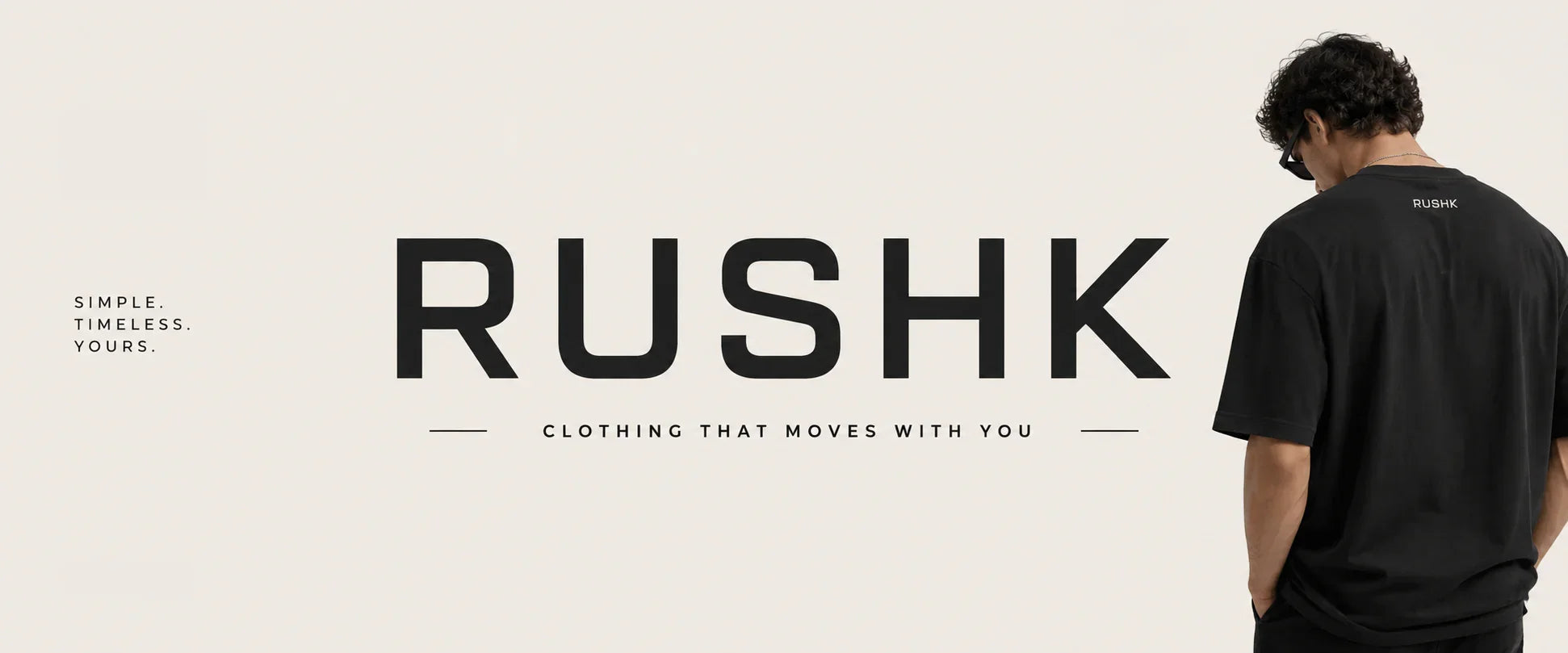 Man wearing black RUSHK streetwear tee, back view, bold logo text, minimalist design